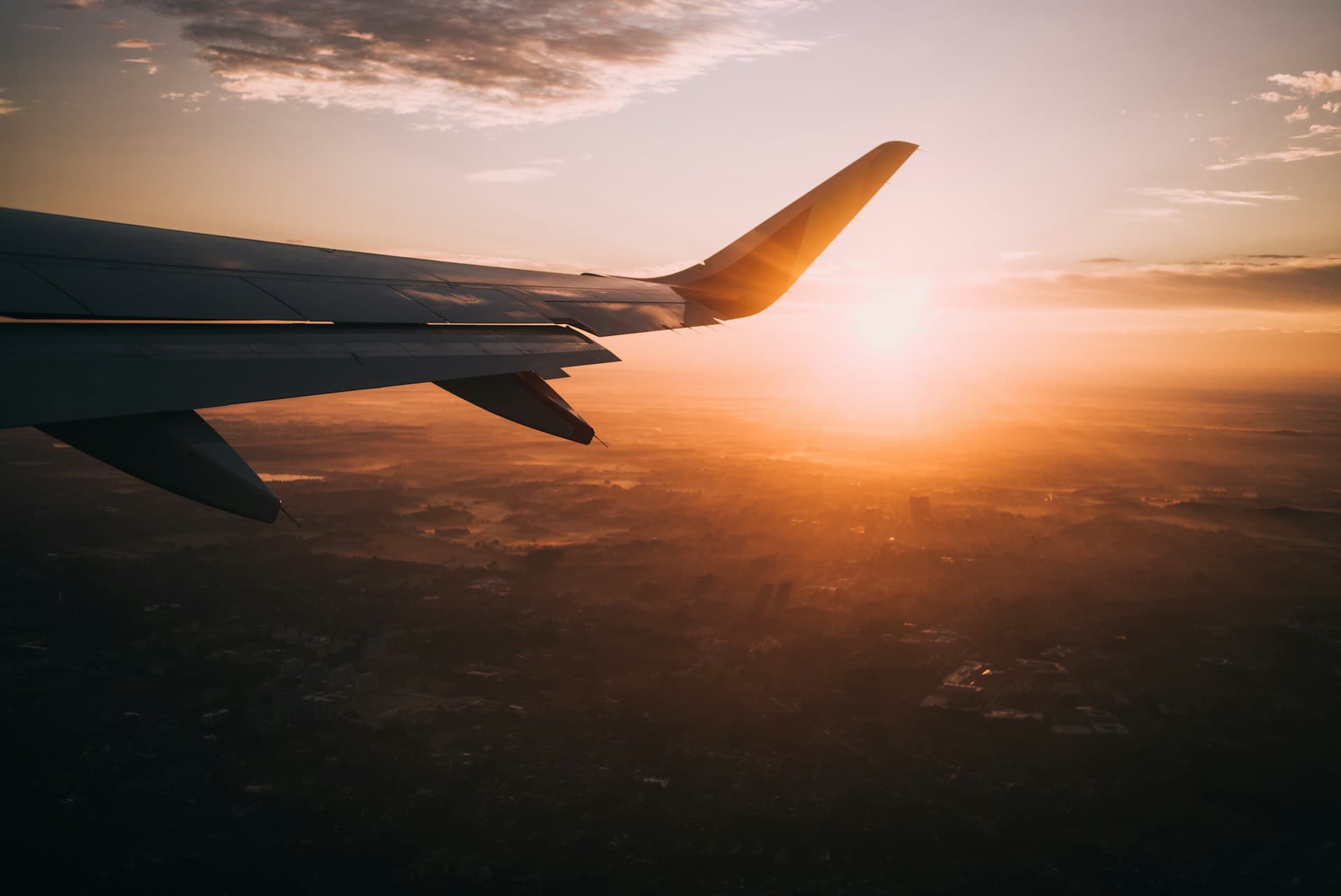 Aile d'avion au coucher du soleil, en plein vol